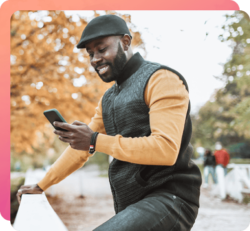 Man looking at his phone while walking on a crisp autumn day